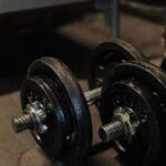Close-up of vintage dumbbells on a rustic floor, ideal for fitness and strength training themes.