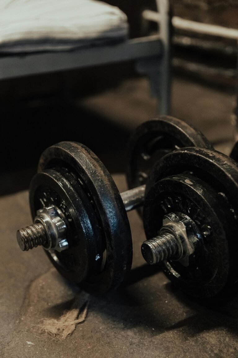 Close-up of vintage dumbbells on a rustic floor, ideal for fitness and strength training themes.