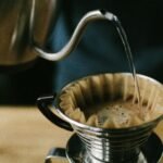 Close-up of a manual pour over coffee brewing process, highlighting the coffee and filter.